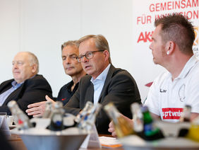(v.l.n.r.): Kurt Gaugler, Geschäftsführender Vorstand der Bundesliga-Stiftung, Charly Körbel, Armin von Buttlar, Aktion Mensch-Vorstand, und Lars Wurst, Spieler beim 1. AFC Amputierten Fußball Club.