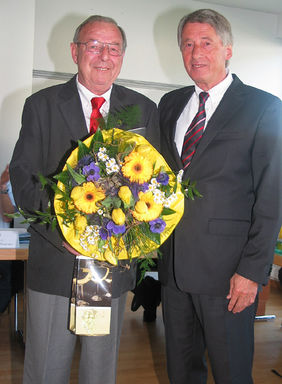 Blumen für den Herrn: Gerhard Koch ist jetzt auch Träger der DFB-Verdienstnadel, überreicht von HFV-Chef Rolf Hocke. Foto: Anne Lange
